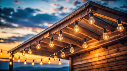 Naklejka premium Close-up of warm glowing string lights hanging from a wooden roof at dusk , string lights, glowing, warm, hanging, wooden