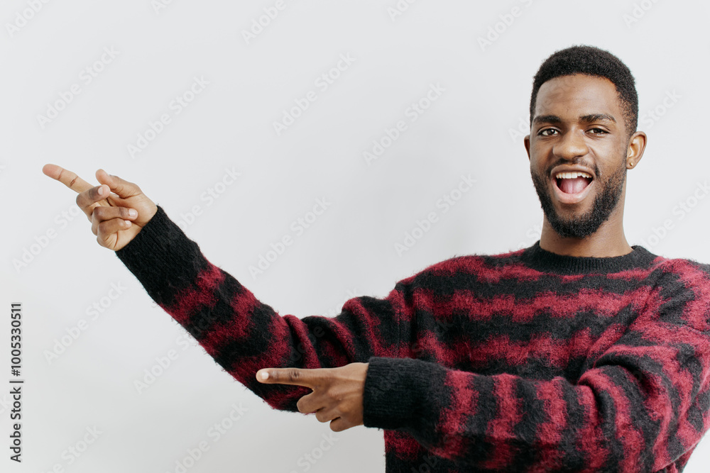 Wall mural confident man in red and black sweater gesturing with right hand in a modern urban setting