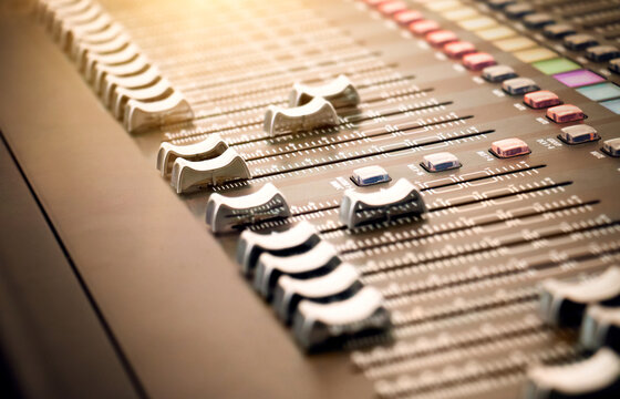 Mixing Desk Console &ndash; Professional Music audio recording mixing board. A row of console faders controls to adjust level of multiple sound input sources and combine signals. Focus on studio slider.