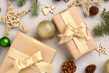 Beautiful composition with fir tree branches, Christmas gifts and balls on grey background