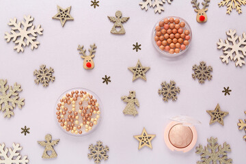 Beautiful Christmas composition with decorative snowflakes, highlighter and blush pearls on light background