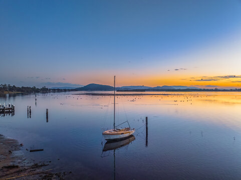 Sunrise waterscape over the bay with birdlife and smoke haze