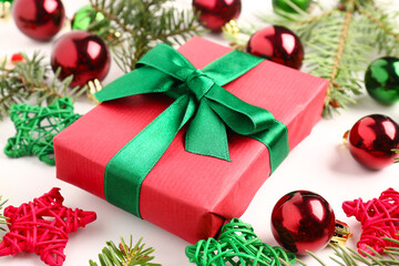 Gift box with Christmas balls, fir tree branches and decorative stars on white background