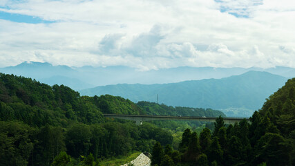 自動車が走行する橋梁と山並みの風景素材・夏