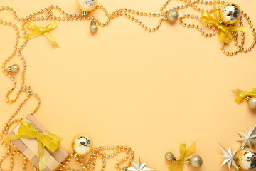 Frame made of beautiful Christmas decorations and gift box on color background