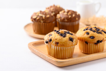 Vanilla chocolate chips muffin on wooden plate with white background
