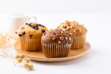 Chocolate almond muffin, Vanilla chocolate chips muffin and Vanilla almond muffin on wooden plate