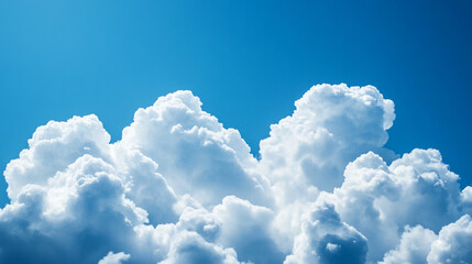 Naklejka premium Fluffy white clouds against a clear blue sky during midday in a serene atmosphere