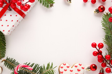 Frame made of gift box, fir tree branches and berries for Christmas celebration on white background