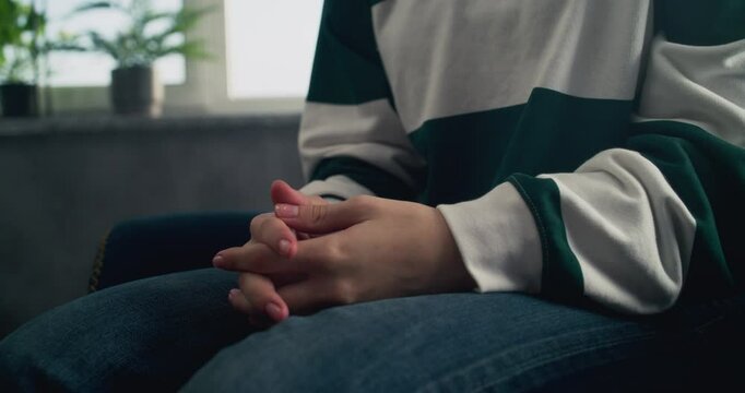 Close up of Caucasian teenage girl sitting in chair, gesturing during communication with psychologist or therapist. Therapy session and psychological support for teenagers. Mental health concept.