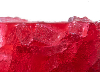 Red carbonated drink with ice,strawberry soda and ice splashing fizzing or floating up to top
