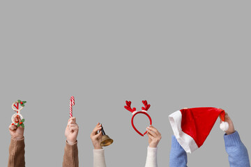 Female hands holding Christmas gift bell with candy cane and accessories on white background