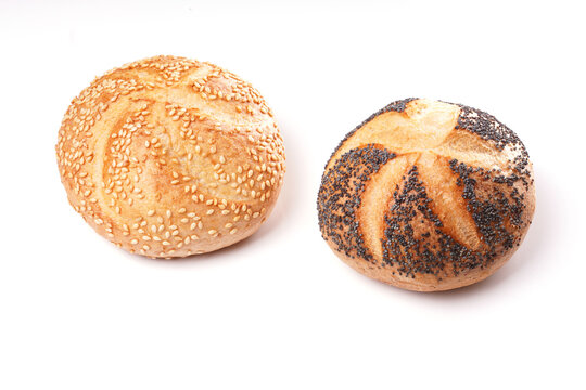 two german bread rolls with sesame and poppy seeds on white kitchen table
