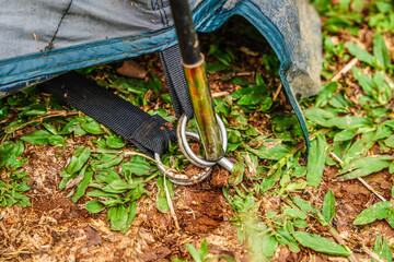 close up of metal tent pegs into the ground. Set up a tent on the grass.