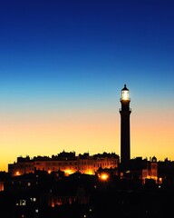 Obraz premium Gentle gradient backdrop from pink to teal, wormseye view of a lighthouse, clear sky for copy