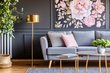 Grey lounge with patterned cushion in real photo of dark living room with floral wallpaper, molding and gold lamp