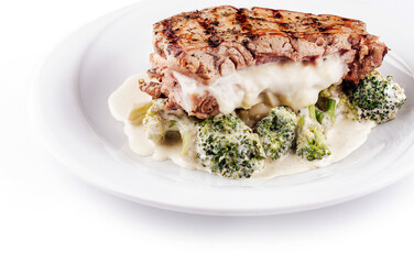 Grilled chicken breast stuffed with cheese and served with broccoli on white plate