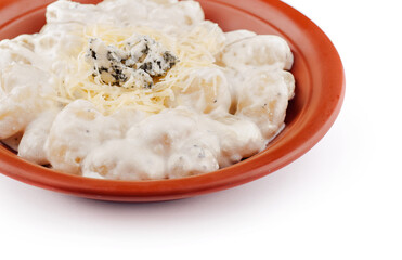 Gnocchi topped with blue cheese and parmesan are served on a plate