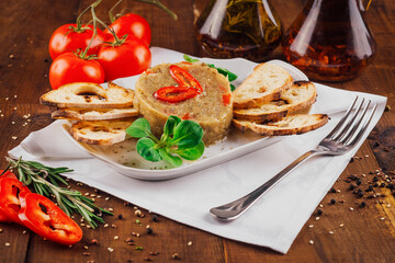 Delicious eggplant salad decorated with chili pepper being served with toasted bread