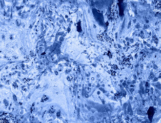Abstract marble background of different shades of blue. Black, blue, white dots. Chaotic spots and blurs. Darker in places, lighter in places.