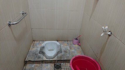 Clean White Sit or Squat Toilet in a Public Restroom