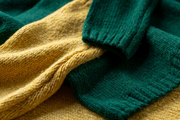 Two hand knitted wool sweaters. Background textures