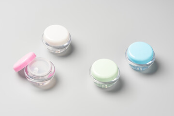 Colorful cosmetic containers arranged neatly on a light gray background