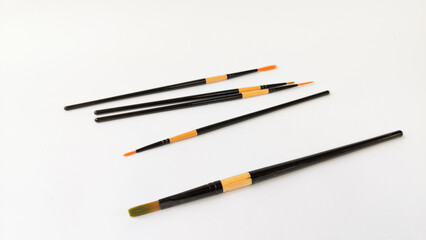 Different brushes with paints on white background