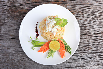 Thai fried rice with crab meat (Khao pad poo) on old wood scene 
