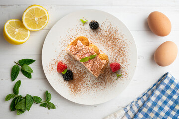 Italian tiramisu with red berry cream. Top view table with  decorations.