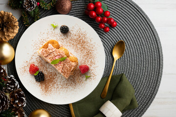 Italian tiramisu with red berry cream. Top view table with Christmas decorations.