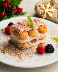 Italian tiramisu with red berry cream. Top view table with Christmas decorations.