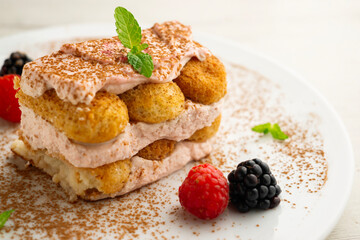Italian tiramisu with red berry cream. Top view table with  decorations.
