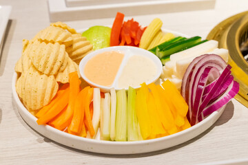 A beautifully plated vegetable salad featuring carrots, celery, red and green peppers, crispy...