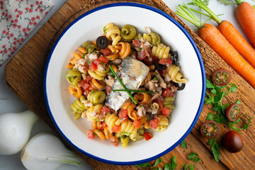 Italian pasta with sardines and black olives. Top view table with  decorations.