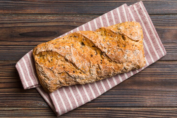 Fresh loaves of bread with wheat and gluten on a colored table. bread on napkin on rustic background, fresh bread top view