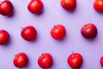 Many red apples on colored background, top view. Autumn pattern with fresh apple above view