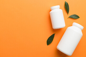 supplement pills with medicine bottle health care and medical top view. Vitamin tablets. Top view mockup bottle for pills and vitamins with green leaves, natural organic bio supplement, copy space