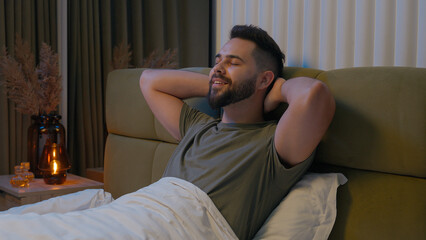 Happy Caucasian man prepare ready bed bedroom male relax cozy comfortable bedtime rest smiling...