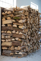 Morceaux de bois pour le chauffage empilés en attendant d'être utilisés en hiver dans un garage. Bois coupé pour le chauffage des maisons, pile de bois de chauffage sur un tas.