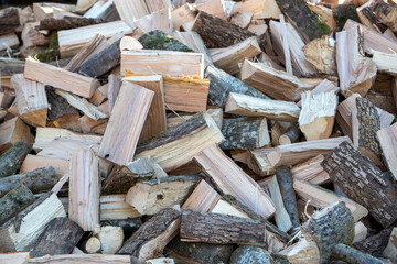 Tas de morceaux de bois pour le chauffage poser en extérieur, attendant d'être rangé dans un abri. Bois coupé pour le chauffage des maisons, prêt à être stocker pour sécher.