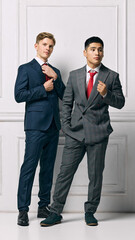 Team. Male Professionals showcasing modern elegance, both present strong and poised stances against white studio background. Concept of business, male fashion, style, beauty, aesthetic. Ad