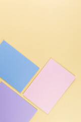 Top view of pink, purple and blue notebooks on yellow background. School, office wallpaper. Flat lay, copy space.