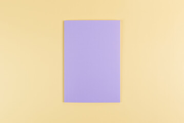 Fototapeta premium Top view of purple notebook on yellow background. School, office wallpaper. Flat lay, copy space.