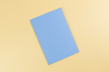 Top view of blue notebook on yellow background. School, office wallpaper. Flat lay, copy space.
