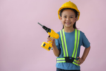 Little handyman with tools Cute child is a construction worker playing with a screwdriver, hammer, drill, construction equipment, and engineering, the dream job of a young Asian girl in the future.