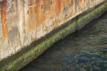 old, dirty and worn out quay wall by the sea