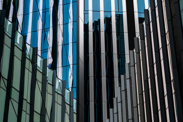 A striking photograph of a reflective skyscraper facade, capturing intricate abstract patterns and distortion effects, highlighting urban architectural creativity.