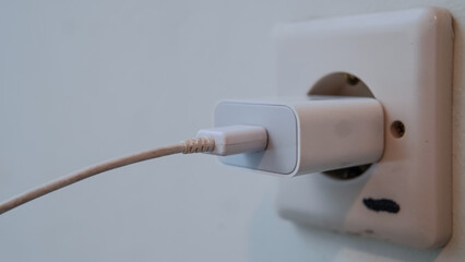 An adapter and charger cable to charge the cellphone are installed in a wall socket