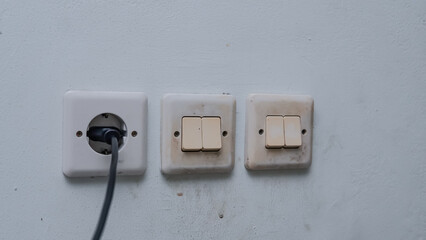 An black adapter are installed in a wall socket